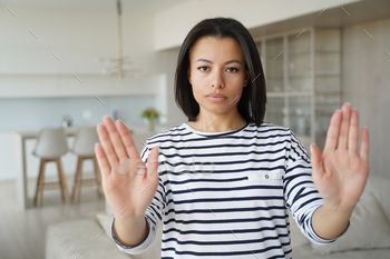 Serious woman showing stop hand gesture protesting against domestic violence, abuse or abortion