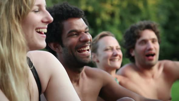 Four friends laughing while sitting in nature