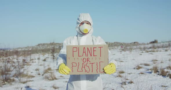 Portrait of Man Wore in Cover Suit Show Protest Sign Planet or Plastic at Camera