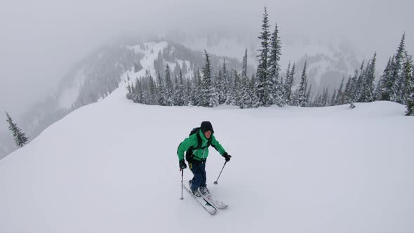 Amazing Ski Touring Aerial Of Man Hiking To Mountain Summit Slow Motion