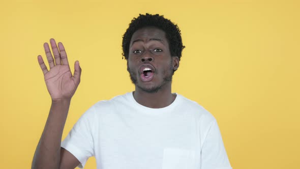 African Man Waving Hand To Welcome, Yellow Background