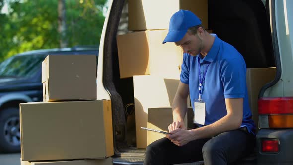 Delivery Worker Checking Parcel Amount in Van, Stocktaking Report on Tablet