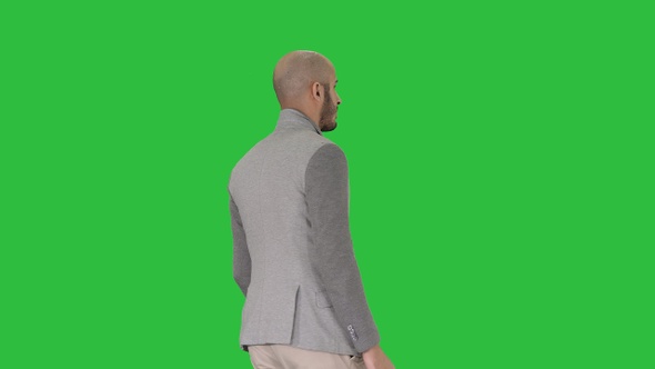 Casual man putting blazer on It is getting cold on a Green