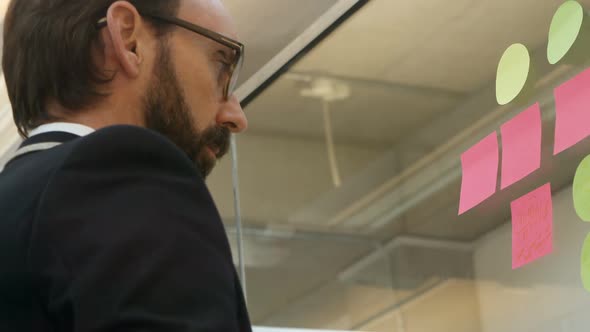 Businessman writing on sticky note