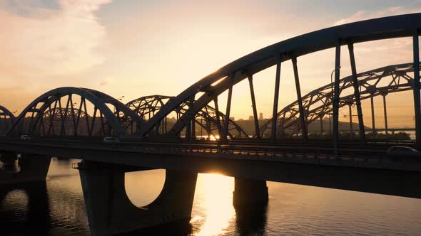 Side Aerial View of a River Bridge with Evening Sunset Shine