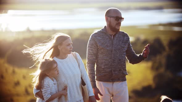 Young Slavic Family Standing on the Wheat Field and Looking Straight