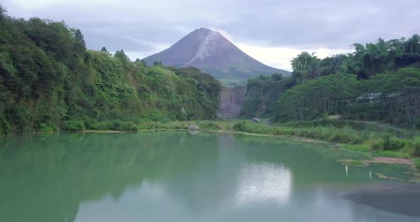 Blue lake surface with Mount Merapi in the background. Bego Pendem is the name of the place for the