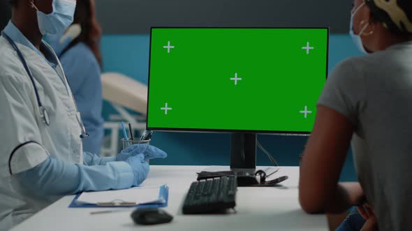 Close Up of Woman and Doctor Looking at Green Screen on Computer