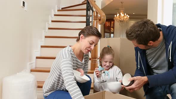 Family unpacking cardboard boxes in there new home 4K 4k