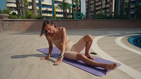 Sporty Woman Doing Workout with an Animal Flow Move Outdoor Near the Pool