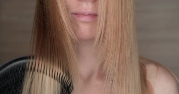 Caucasian woman combing her long hair.