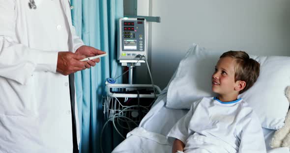 Male doctor using digital tablet during visit in ward