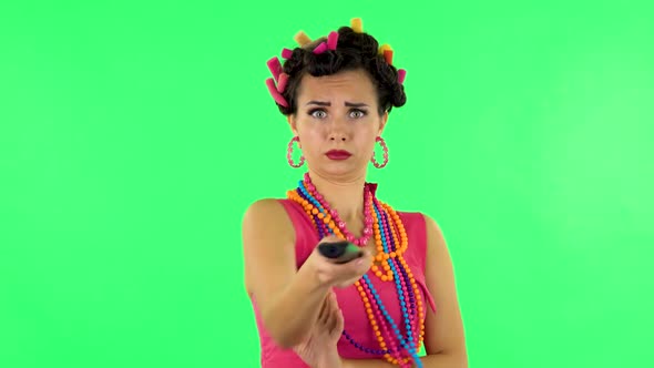 Woman with TV Remote in Her Hand, Switching on TV. Green Screen