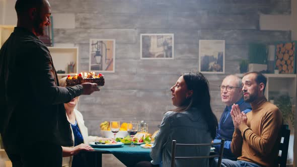 Excited Young Woman When Her Husband Arrives with Delicious Cake