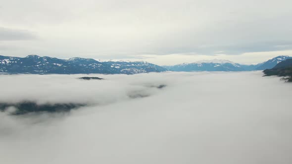 Aerial View of Canadian Mountain Landscape Covered in Fog Over Harrison Lake