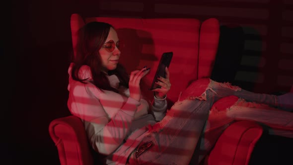 Woman Messaging on Smartphone on Armchair