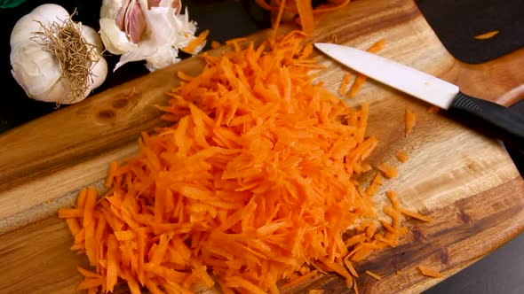 Grated fresh carrot on a wooden board close up zoom in