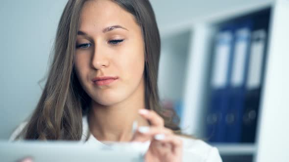 Attractive Businesswoman Using a Digital Tablet in Office