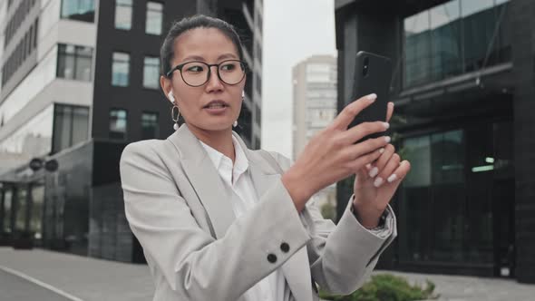 Asian Businesswoman Talking on Video Call Outside