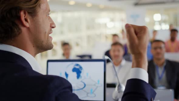 Male speaker and applauding audience at a business conference