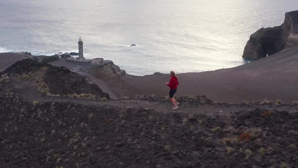 Jogger Running on Footpath with Capelinhos Volcano on Background Faial Island