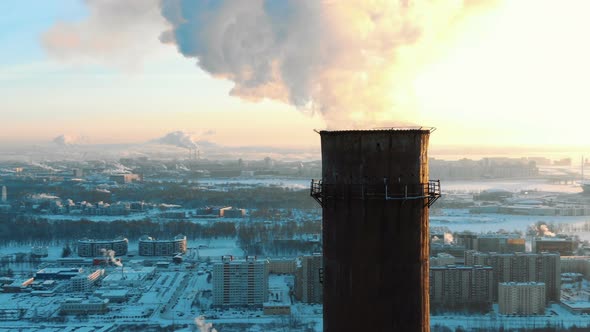 Aerial View of Smoking Chimneys in a Residential Area of the City at Sunset in Winter