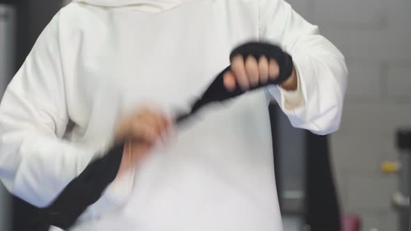 Strong Muslim Woman Prepares for Training Boxing Alone in the Gym Woman Ties Ricky Elastic Bandages