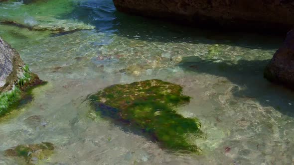 Sunny Beach with Blue Sea Water, Blue Sky and Rocks on the Horizon in a Summer Day. Closeup.Details