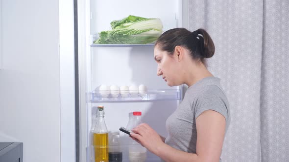 Housewife in Grey Tshirt Makes List to Buy Food Products