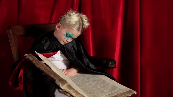 Young girl dressed as wizard, reading book of spells