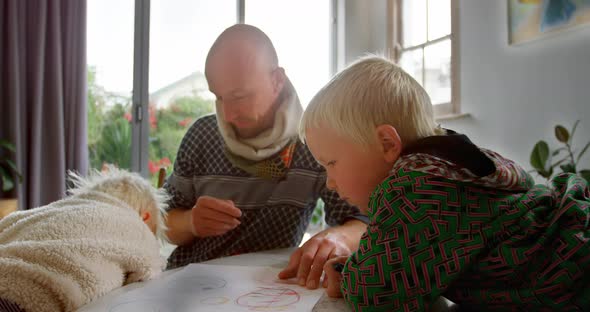 Father helping his children in drawing at home 4k