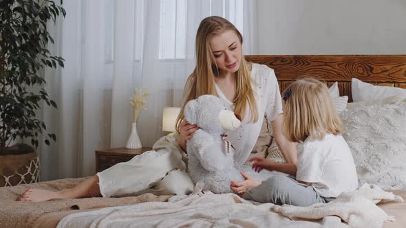 Little Girl Caucasian Daughter Preschool Child Kid Sitting with Mother Beloved Mom in Bed in Bedroom