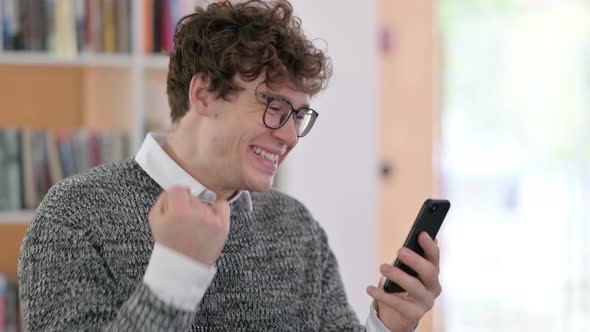 Portrait of Young Man Celebrating on Smartphone