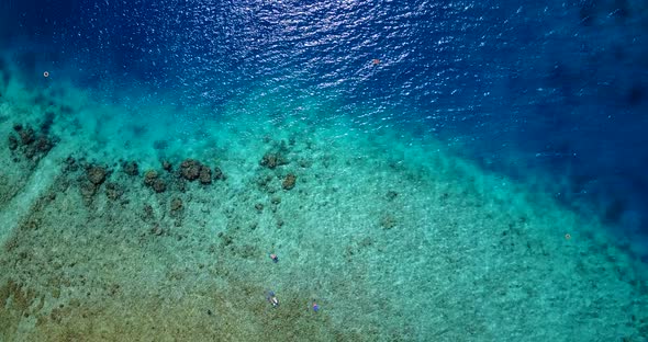 Wide drone clean view of a sunshine white sandy paradise beach and blue water background in vibrant 