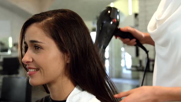 Woman getting her hair dried with hair dryer