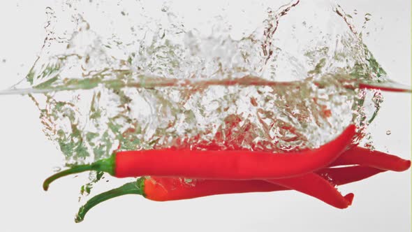 Super Slow Motion Chilli Pepper Falls Into the Water with Splashes