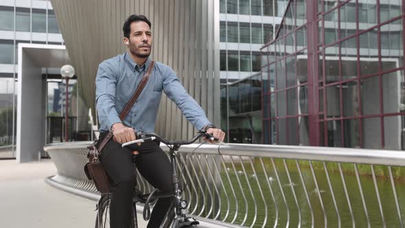 Businessman in Earphones Getting to Office By Bicycle