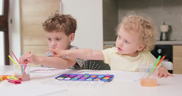 Brother and Sister Draw Watercolors While Sitting at the Table Sister Wants to Change the Paintbrush