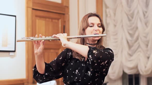 Flute1Young woman playing a large concert flute