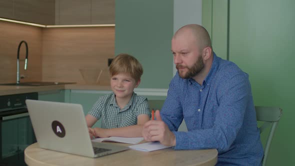 Dad Helping His Son with Online Studying