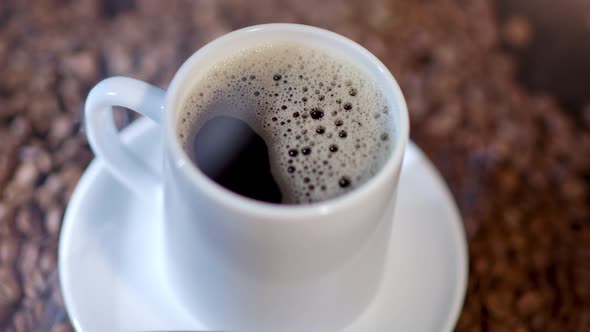 A Cup of Delicious Coffee Has Been Cooked and is Served on Top of Many Coffee Beans