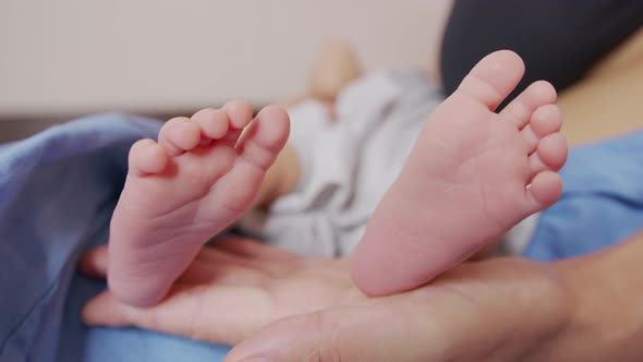 Little Feet of a Newborn Baby. Caring for a Child. Closeup.