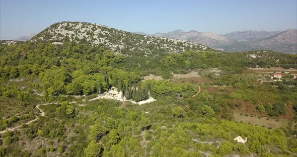 Church hidden in hills of Dubrovnik, Croatia. Aerial shot over beautiful Croatian hills on a sunny d