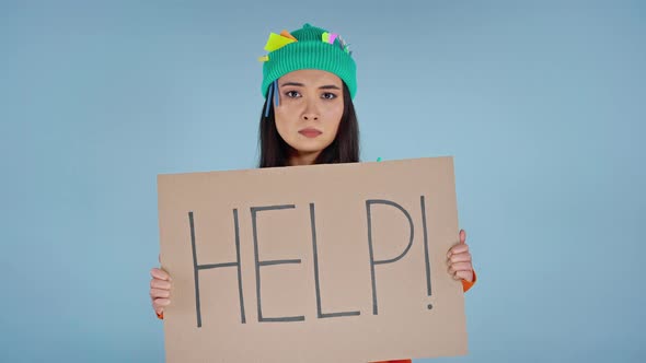 Woman holding cardboard with isncription help on it