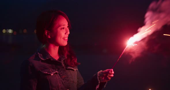 Woman play sparkler at night