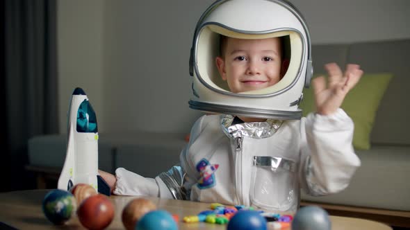 A Child Plays at Home in an Astronaut a Funny Portrait of a Little Boy 56 Years Old in a Toy