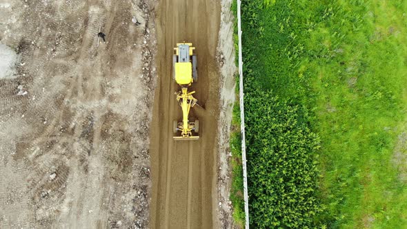 The tractor aligns the ground. Construction of the road from a height.