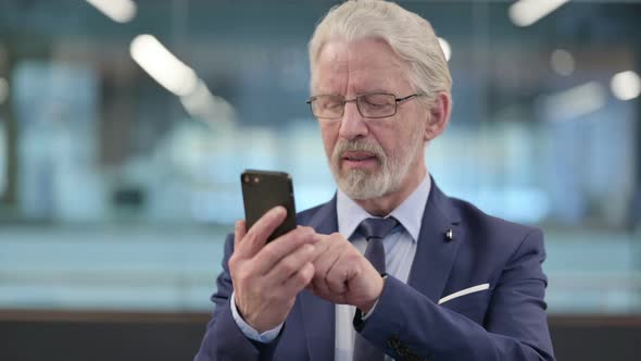 Portrait of Old Businessman Celebrating on Smartphone