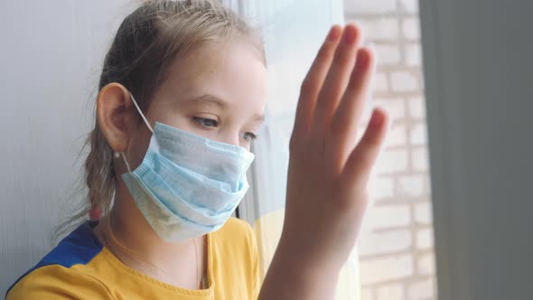 Little Girl in a Protective Mask Sits in Quarantine at Home