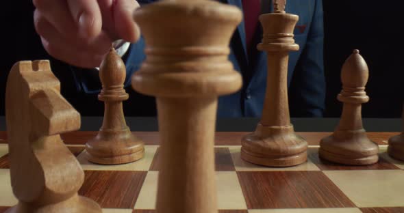 Close Up of Man Making Move with White Bishop on Chessboard During Chess Game